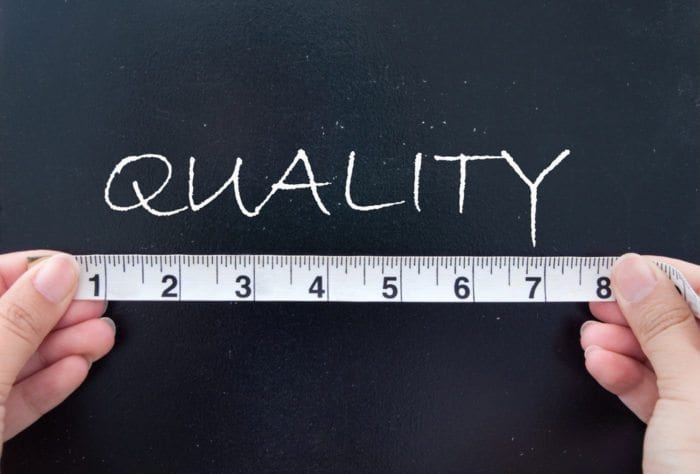 a man with a ruler and the word quality