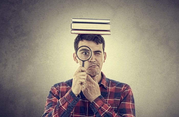 a man looking through a magnifying glass to show people search online.