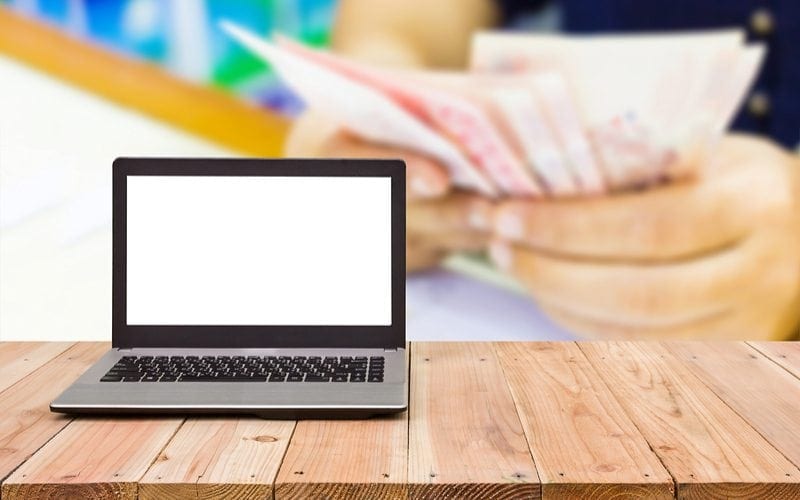 Holding money behind a laptop