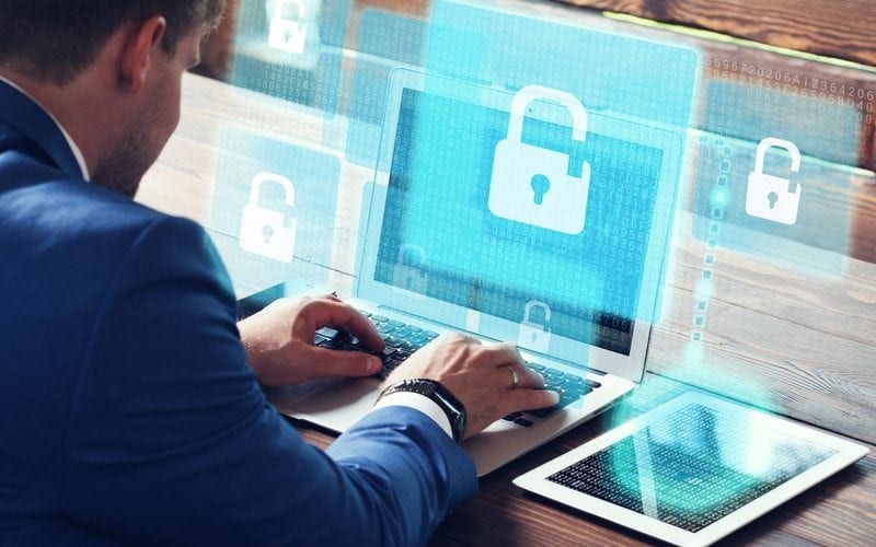 Business professional sitting logging into a secured website on his laptop
