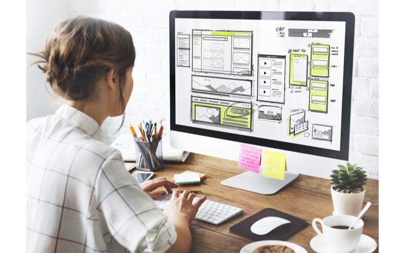 Designer at her computer planning out a website layout for her Medical Website Design