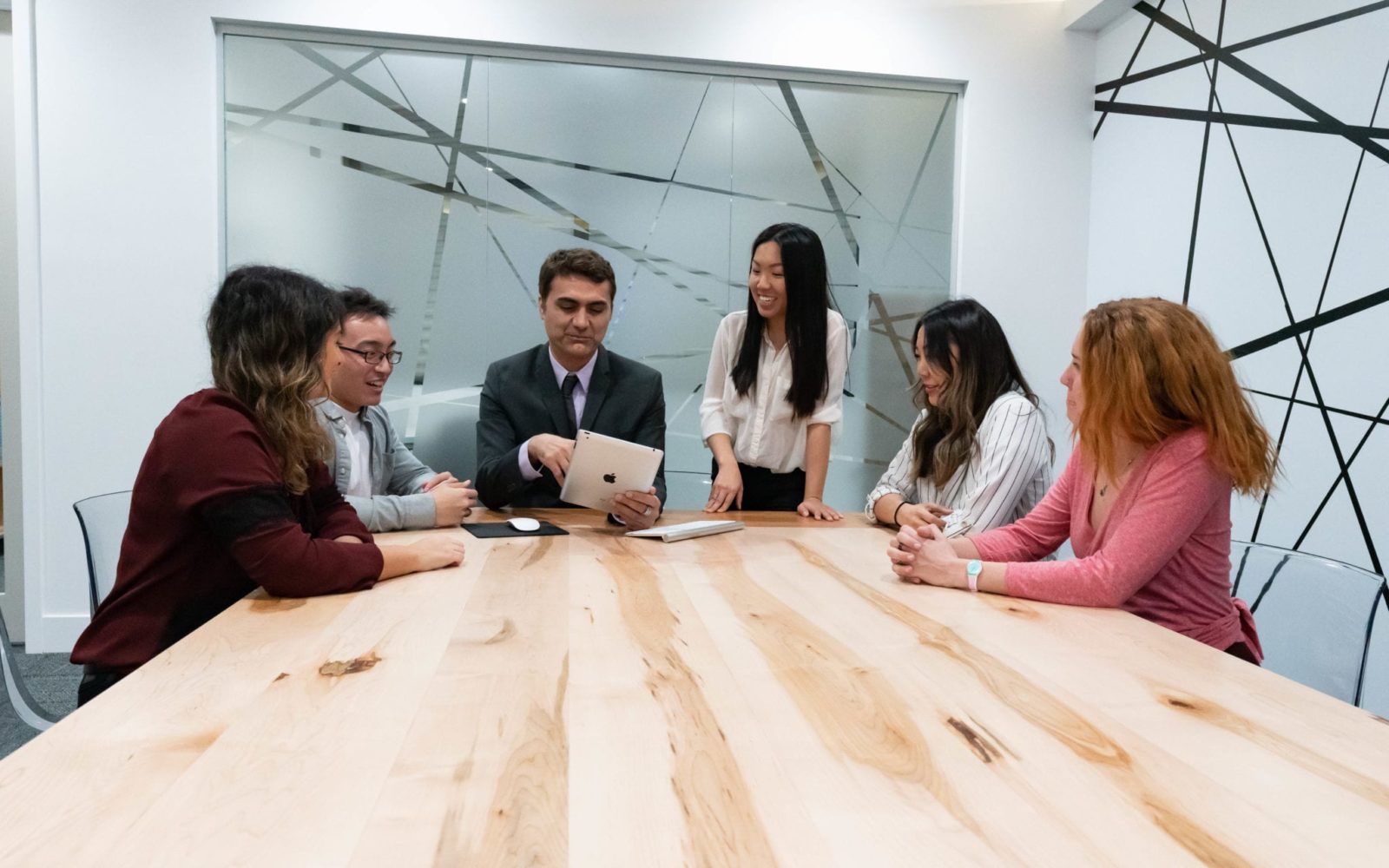 Dr. Sean Fahimi, Belinda Tran, Suzanne L., Matt B., Leyla S. and Christina testing a website on ipad in the conference room at O360® HQ