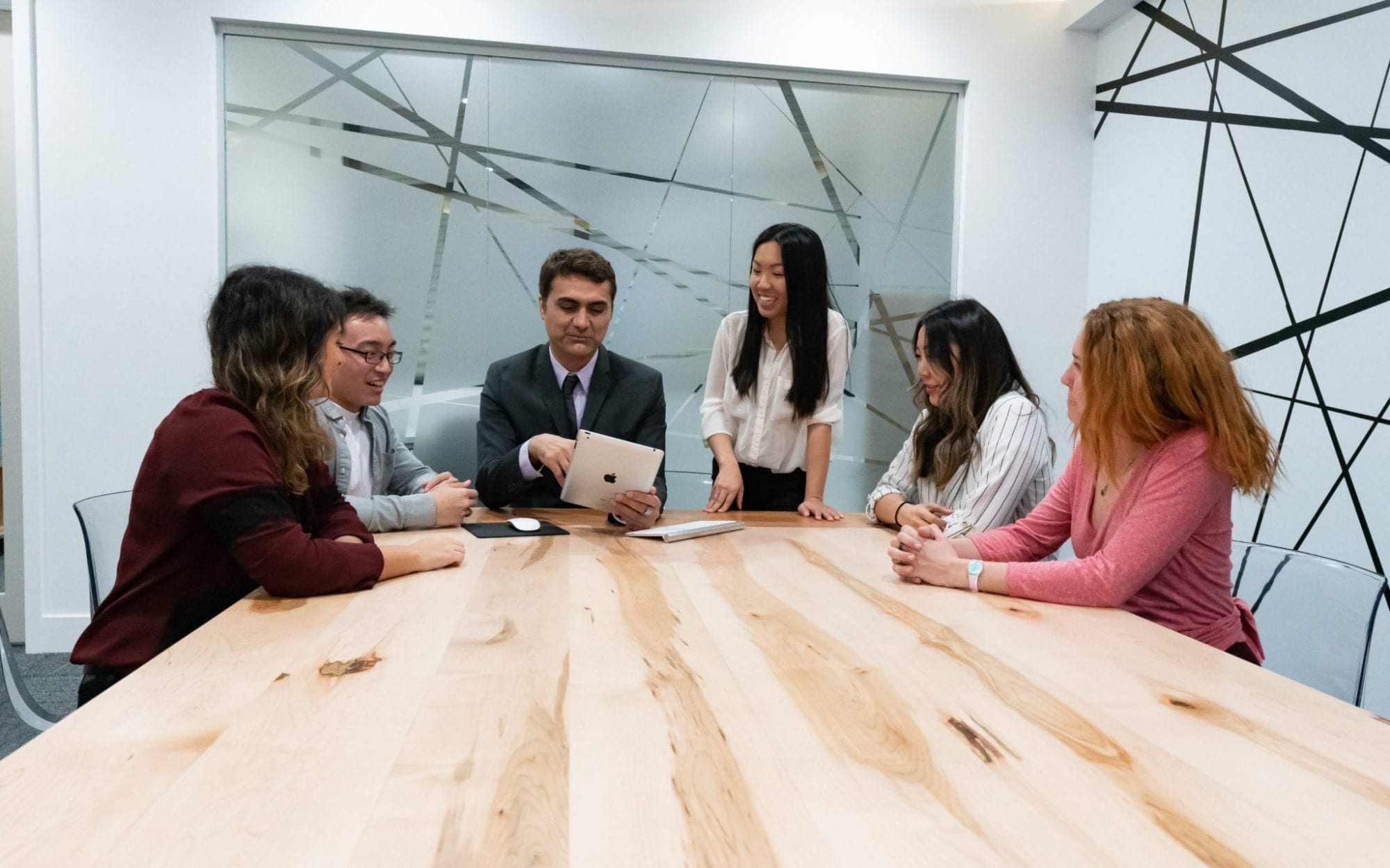 Dr. Sean Fahimi, Belinda Tran, Suzanne L., Matt B., Leyla S. and Christina testing a website on ipad in the conference room at O360® HQ