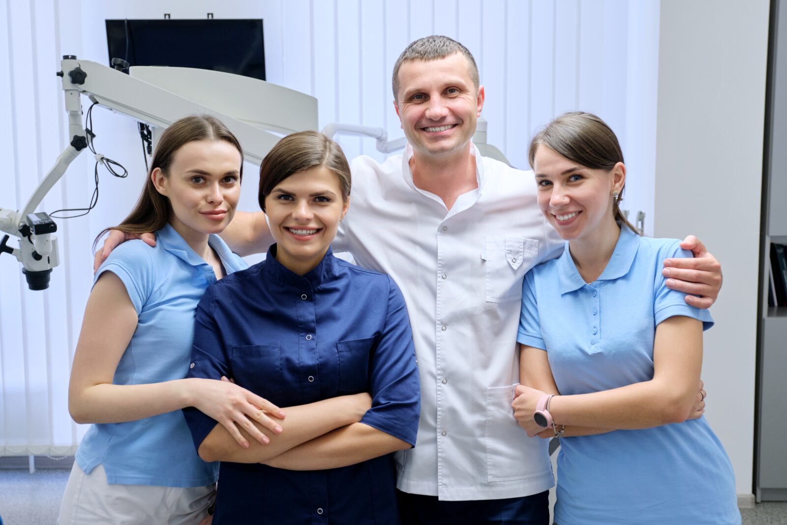 Portrait of male doctor dentist and female interns in the dental office